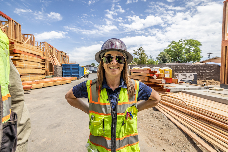 JPI construction team member on jobsite near lumber