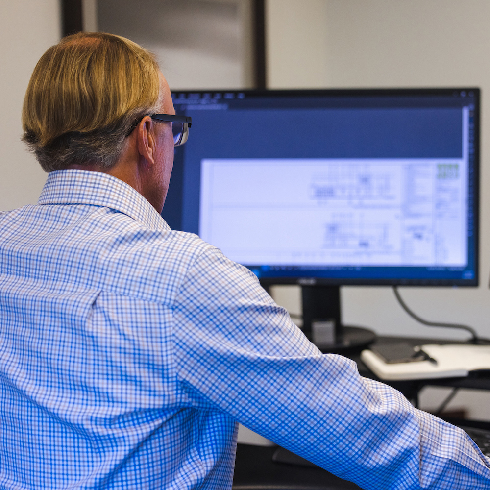 JPI associate reviewing construction drawings on computer